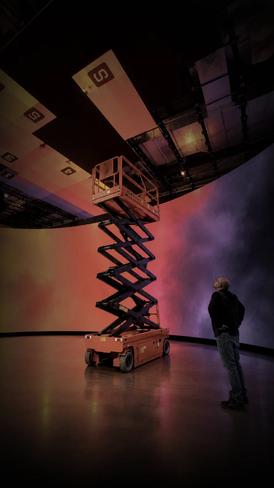 Scissor lift raised toward the curved LED ceiling