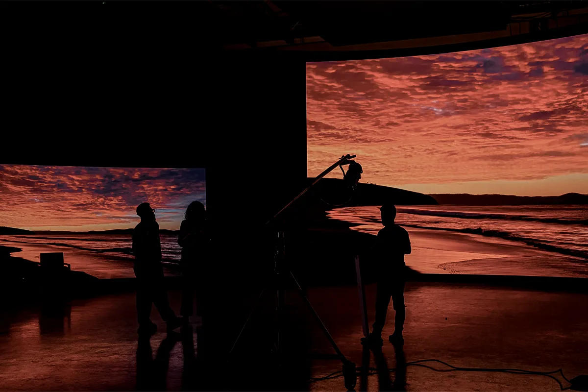 Crew filming a sunset beach scene on Gamma's curved LED stage