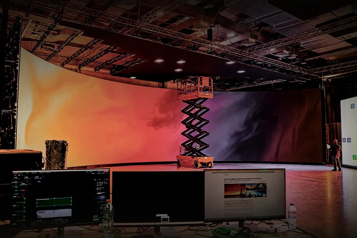 Scissor lift on the stage floor in front of the curved LED wall and ceiling